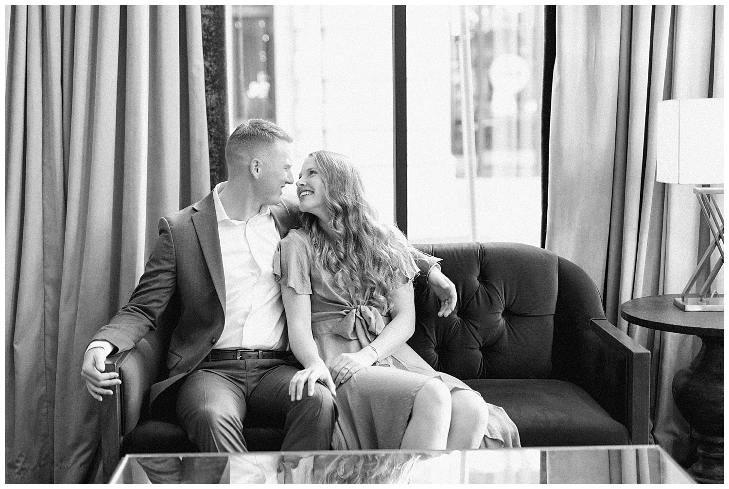 classy downtown engagement session black and white picture of rachel and cam on the green couch